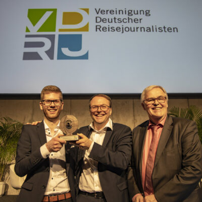 Falk Olias (l.; Geschäftsführer Runa Reisen) freut sich mit Karl B. Bock (m.; Geschäftsführer Runa Reisen) über den Columbus Ehrenpreis 2019, den ihm Rüdiger Edelmann (1. Vorsitzender & Sprecher der VDRJ) überreicht hat; Foto: Holger Leue